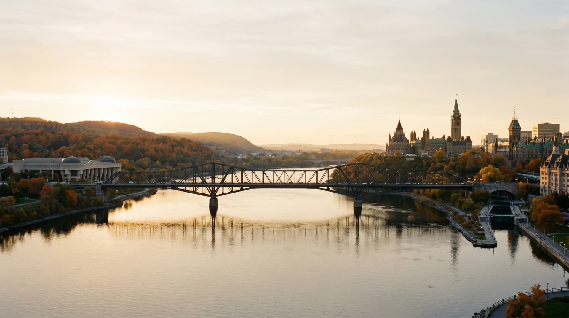 The Ottawa River with a steel-truss bridge spanning between Ottawa and Gatineau at golden hour, with heritage stone buildings on the Ottawa side and autumn-coloured Gatineau Hills on the left — the National Capital Region Distinctive Form serves on both sides of the border