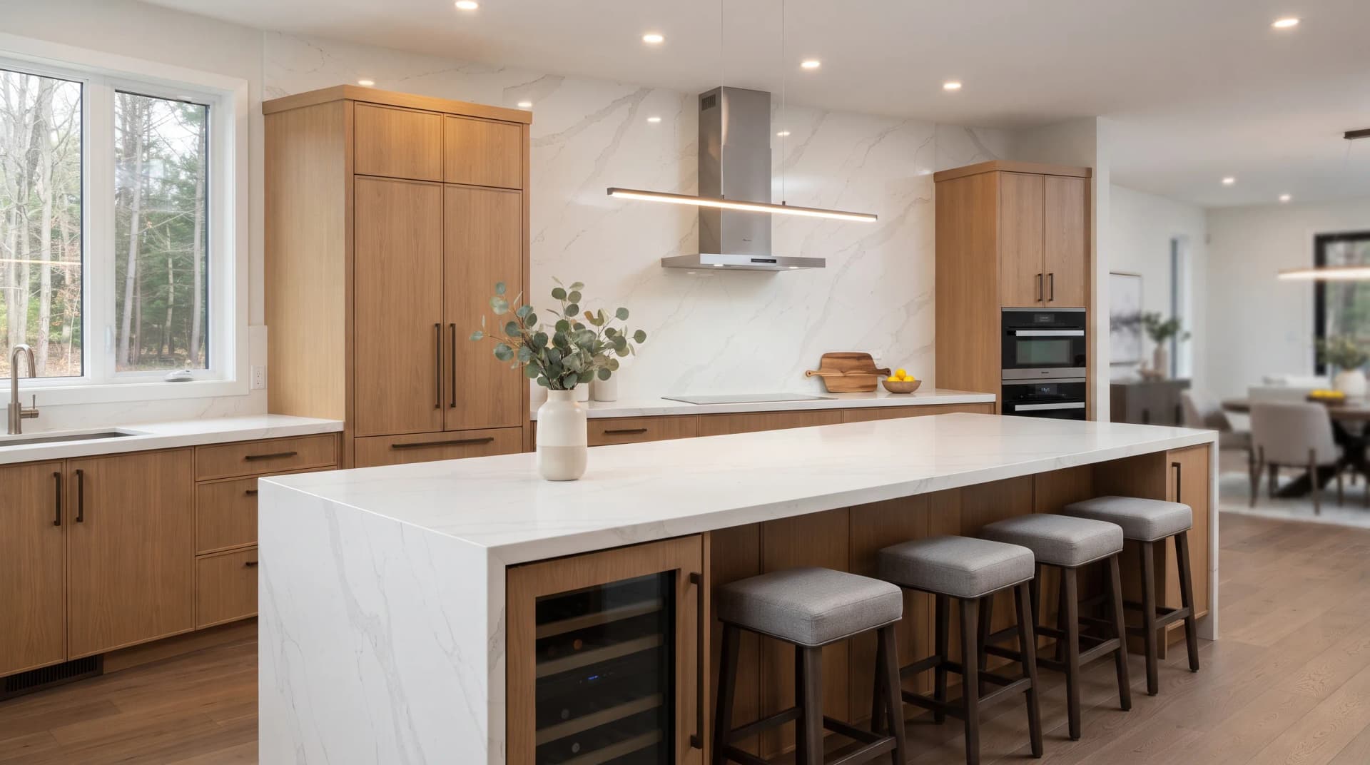Cohesive modern kitchen where the quartz countertop and full-height backsplash read as one continuous engineered stone surface
